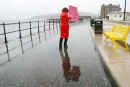 Woman in red raincoat battles the weather for North Ayrshire Council