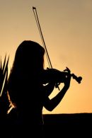 Nicolla Benedetti sillhouetted against the sun as she plays violin